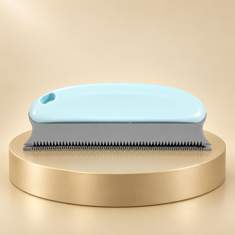 Pale blue handheld pet hair remover with gray fine-toothed edge on a round champagne display plinth