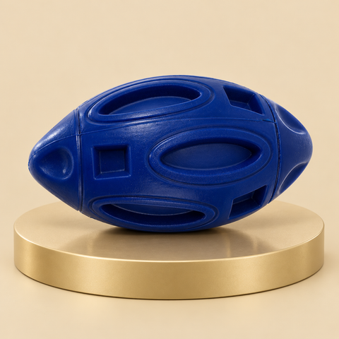 Navy rubber football dog toy with raised oval panels and square recesses on a round champagne plinth