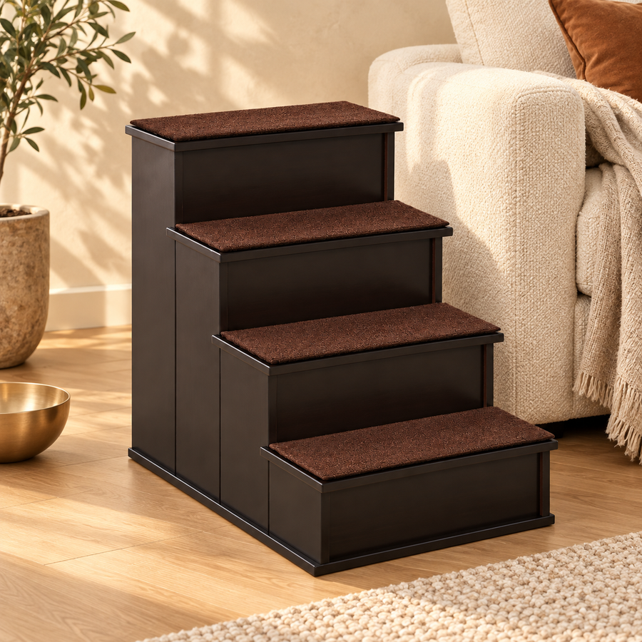 Four-step dark wood dog stairs with brown cushioned treads beside a cream sofa and knit throw