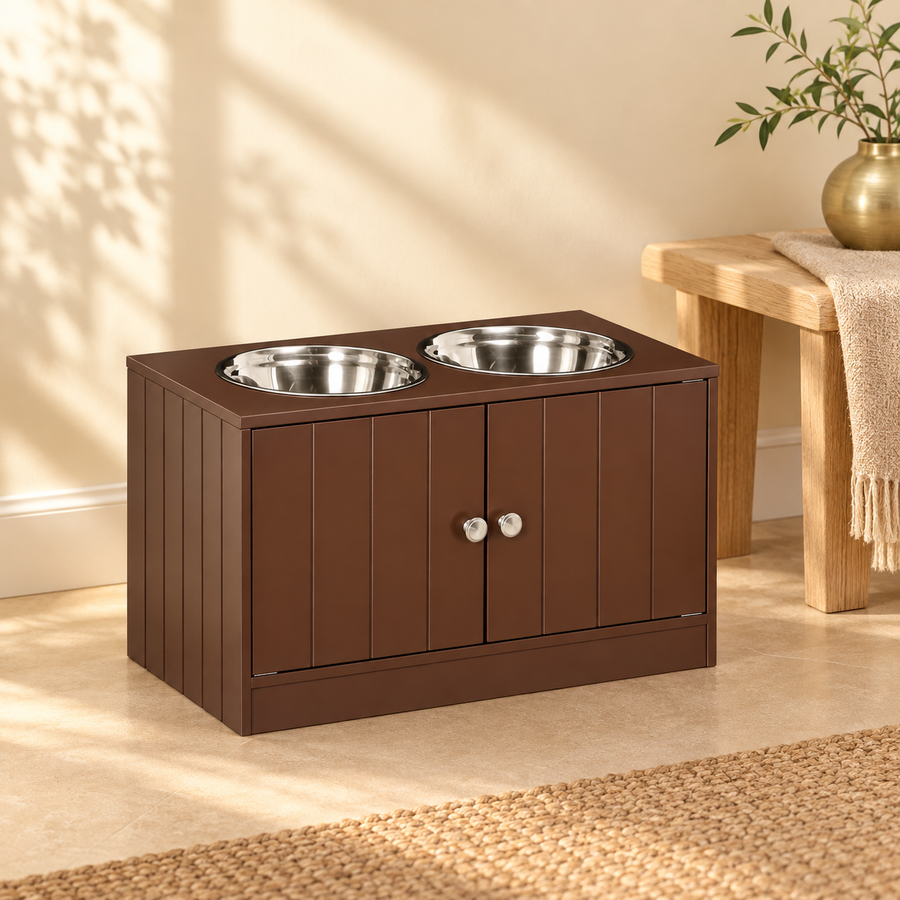 Brown raised dog feeding station with two steel bowls and two knobbed doors beside a wooden bench