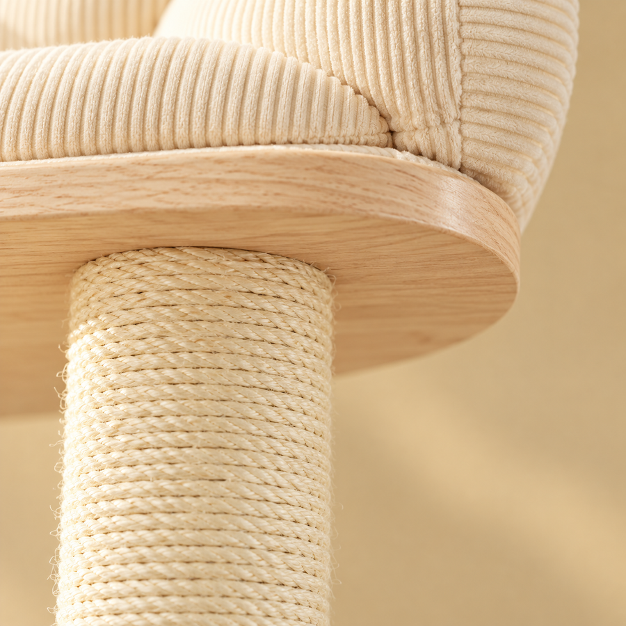 Close-up of the ribbed cream cushion, wood perch edge and rope-wrapped sisal post on a cat tree