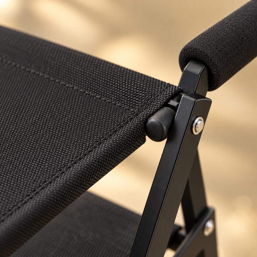 Close-up of a black woven step, foam-padded handle and metal hinge on foldable dog stairs
