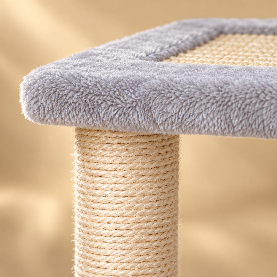 Close-up of natural sisal rope wrapped around a post below a soft gray plush platform with a sisal mat
