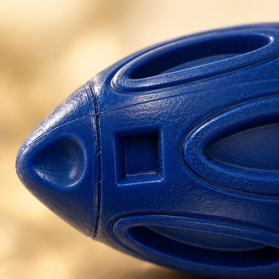 Close view of the raised oval panels, square recesses and rounded end of a navy rubber football toy