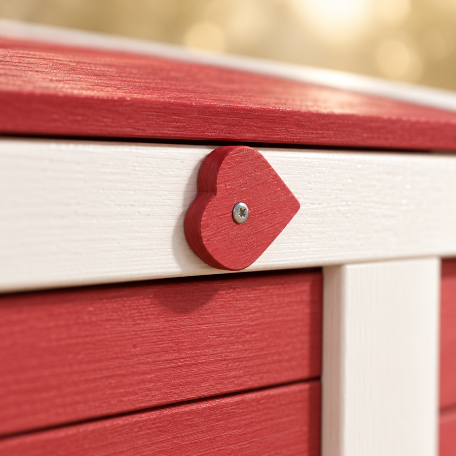 Close-up of a red heart-shaped latch on the white frame and red painted wood planks of a small rabbit house