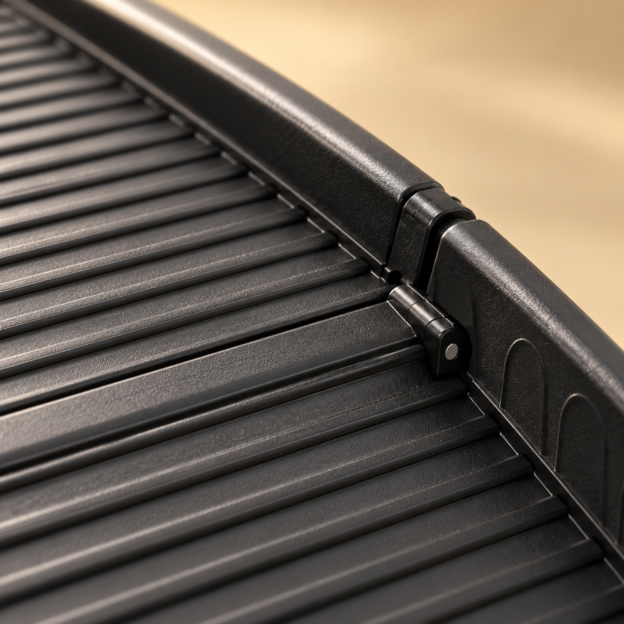 Close-up of the ridged surface, side rail and hinge joint of a black folding dog ramp