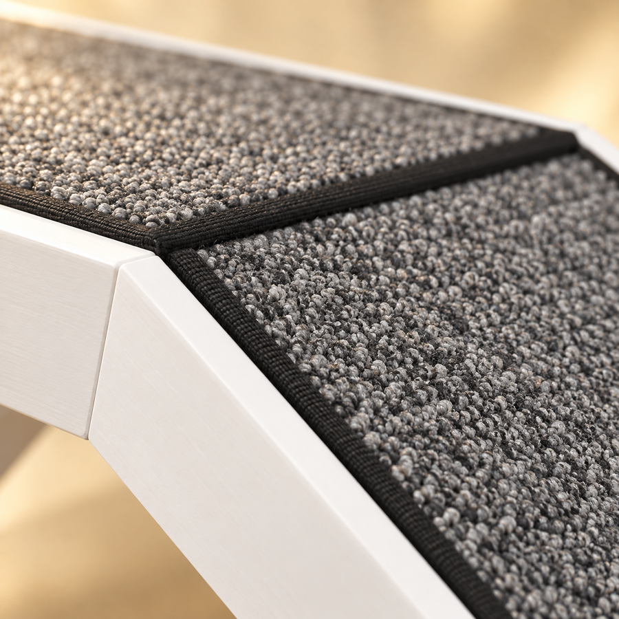 Close-up of the gray looped carpet with black binding at the bend of a white wooden pet ramp