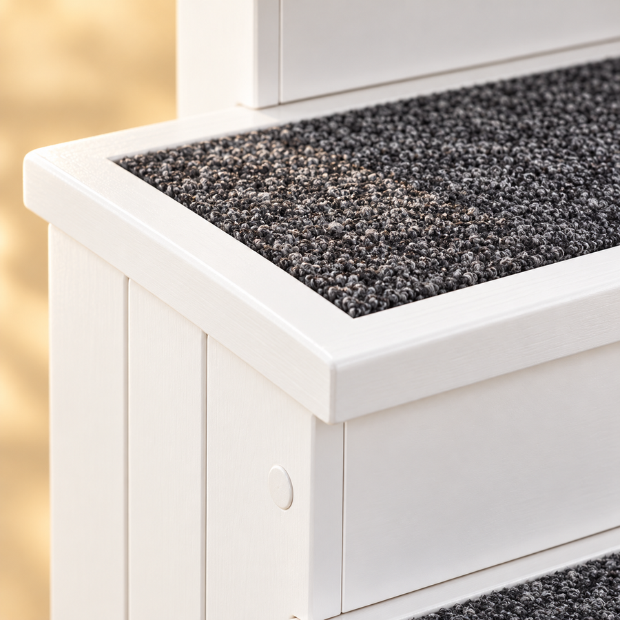 Close-up of the gray speckled carpet tread and white wood edge on a pet stair step