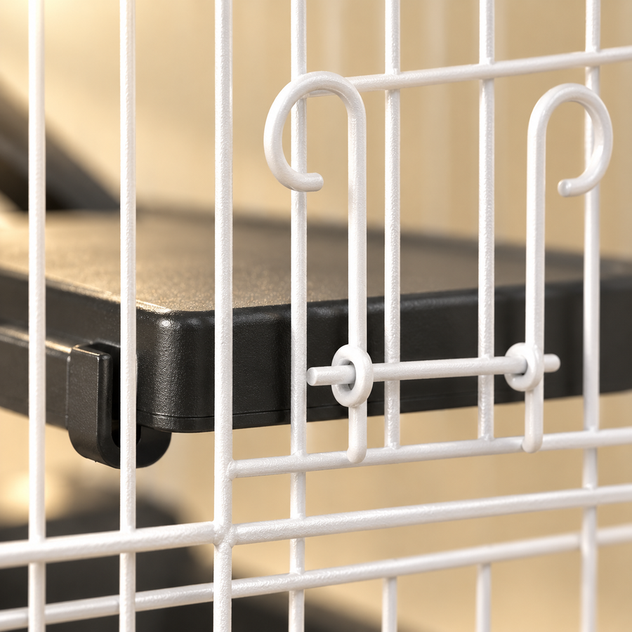 Close-up of white door latch hooks on the wire bars of a small animal cage beside a black plastic platform