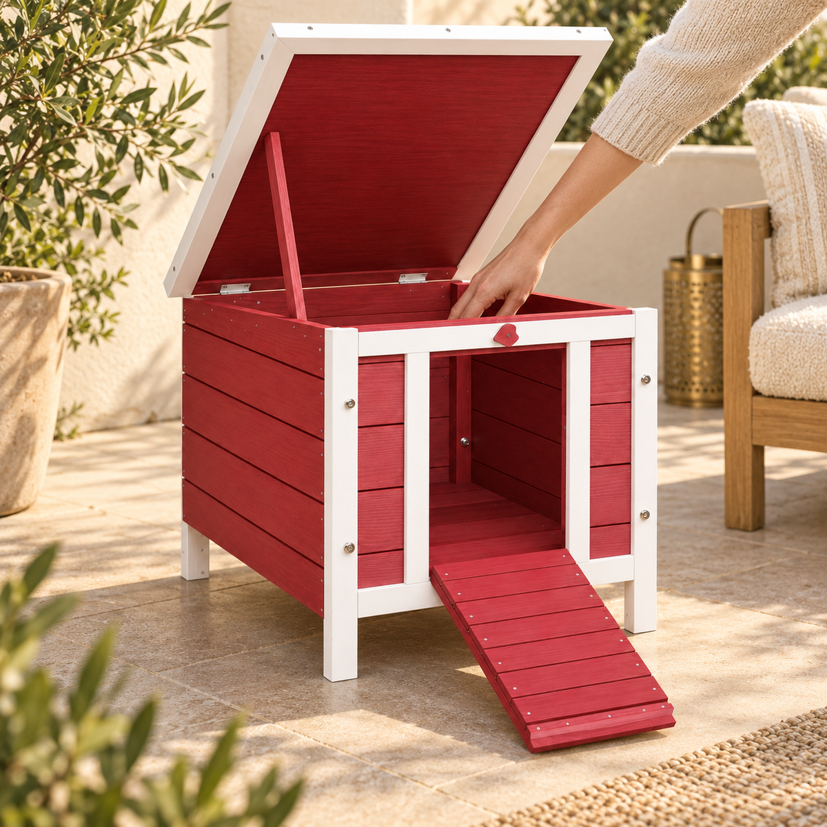 Hand reaching into a red-and-white wooden rabbit house from above, the roof lifted on its red prop stick