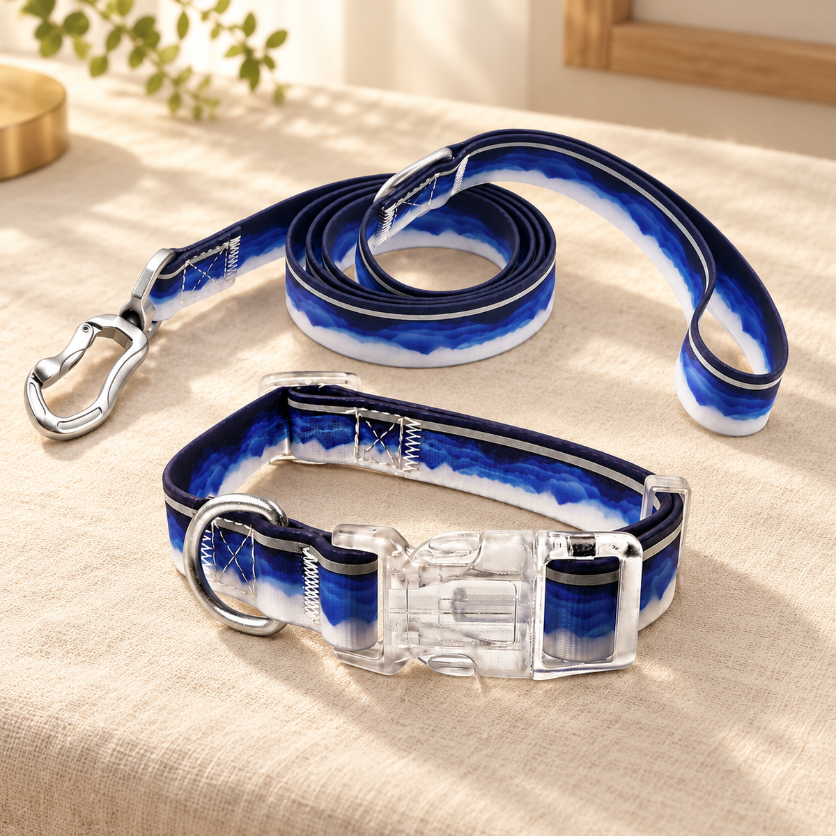 Matching navy-and-white collar and coiled leash resting together on a cream fabric-covered surface