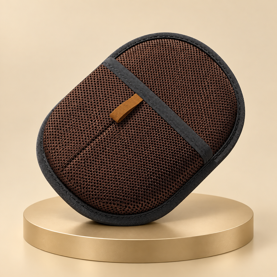 Dark brown pet hair remover mitt with a woven mesh back and tan loop, shown on a champagne plinth